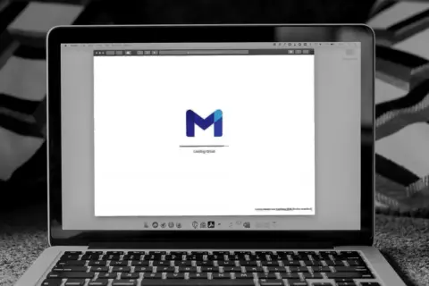 Laptop z otwartym Gmailem, idealny do nauki pisania e-mail po angielsku przykłady.